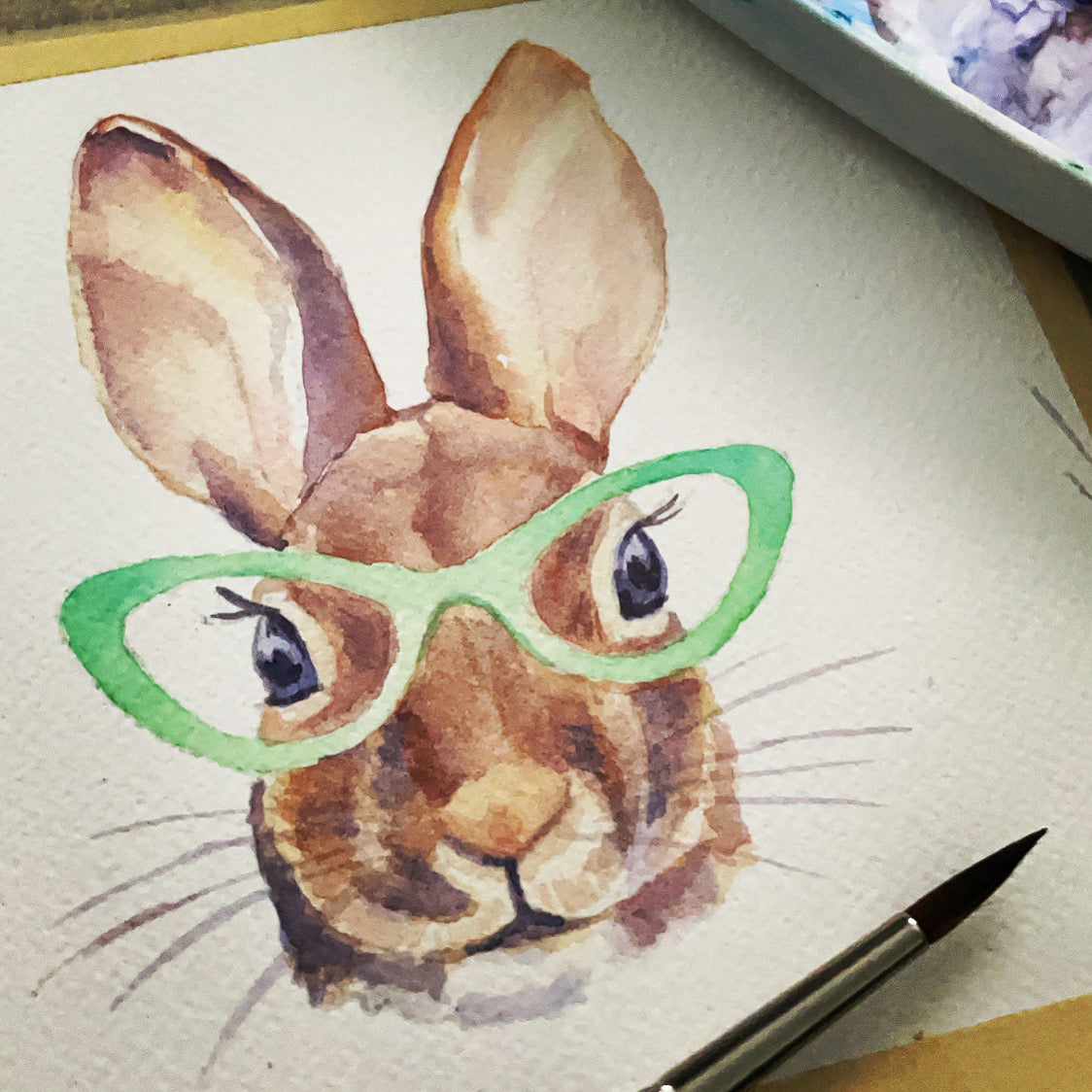 Close up of the original watertcolor painting of a bunny wearing green glasses