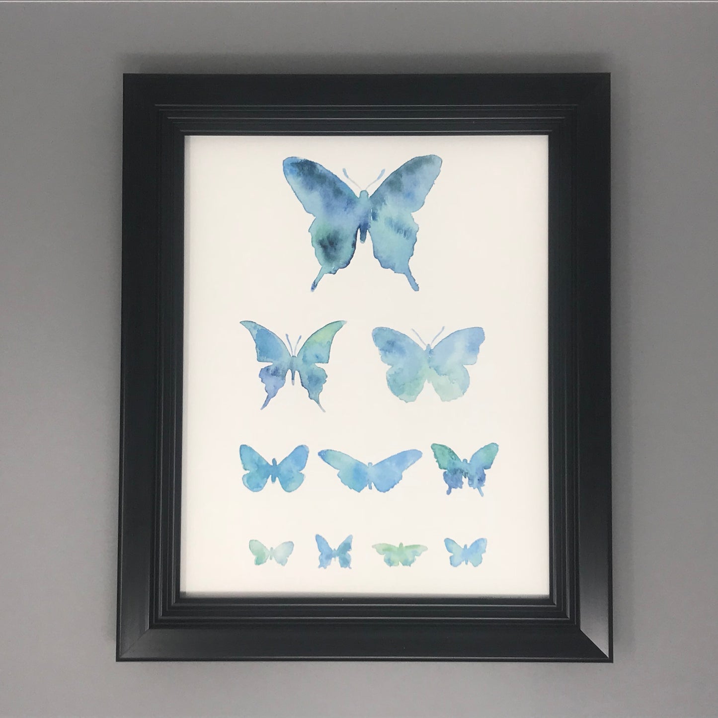 A print of blue / aqua butterflies in an eye chart. 